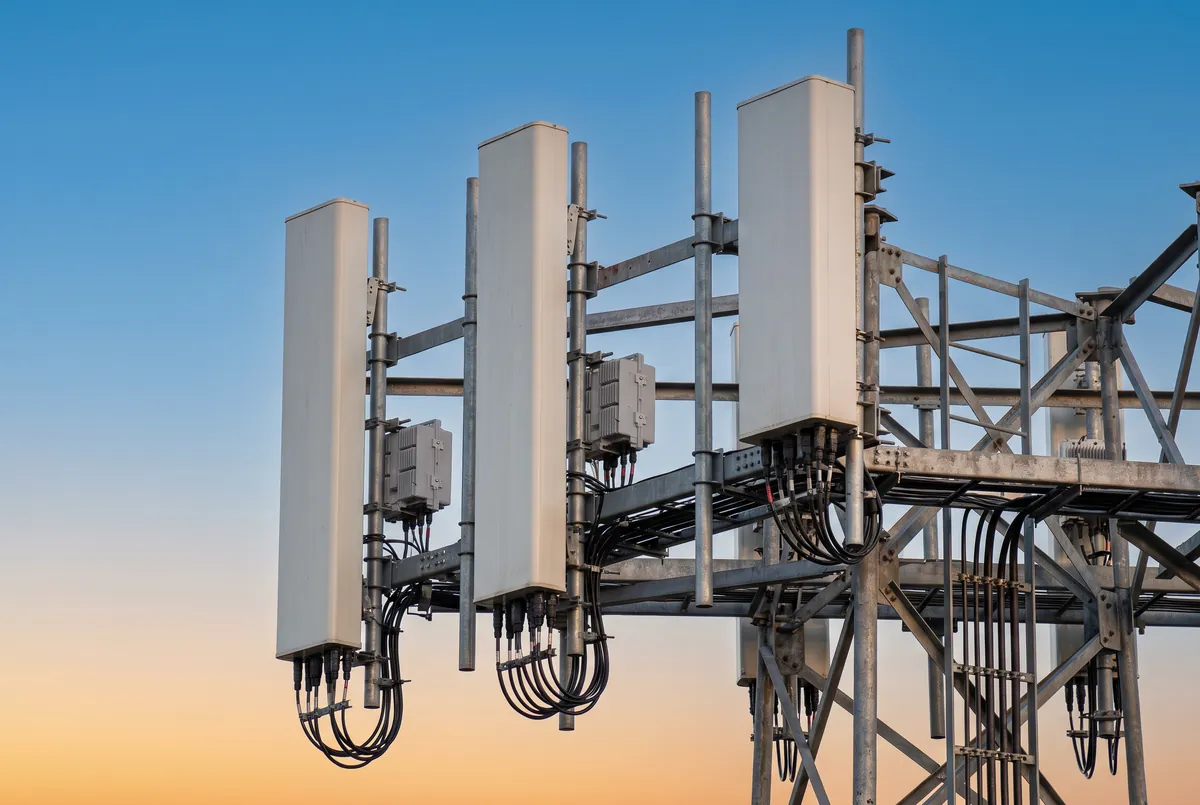 Close-up of 5G panel antennas and remote radio units mounted on a tower sector frame